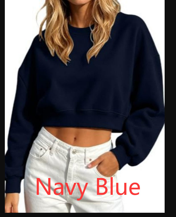 A woman wearing a cropped long-sleeve sweatshirt in navy blue, paired with white jeans. The image has a white background with black side bars and red text overlay reading 'Navy Blue'.